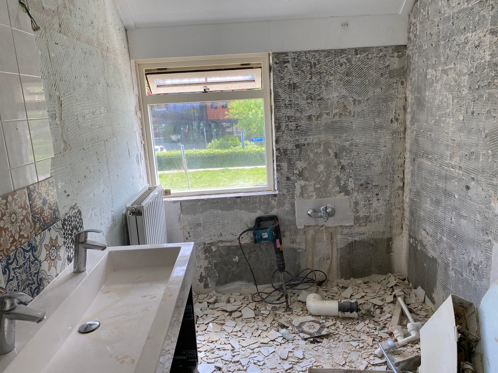 Sloopfase van een badkamerrenovatie: oude tegels en wandafwerking verwijderd